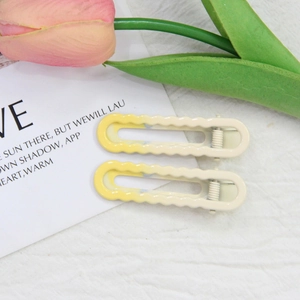 Gros plan de barrettes à cheveux dégradé jaune avec bord ondulé et design évidé