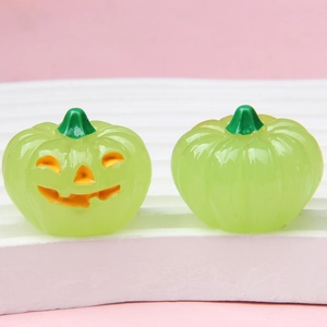 Lichtgevende Halloween pompoen bedeltjes van groene hars op een wit display