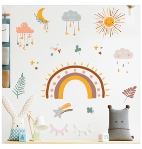 Detail of boho rainbow wall stickers with clouds and stars in a cozy kids nursery room