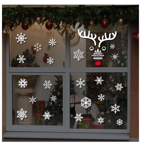 Christmas window stickers with white snowflakes and reindeer face on a glass display