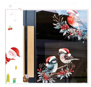 Détail de stickers de fenêtre festifs avec des oiseaux en bonnets de Noël et baies