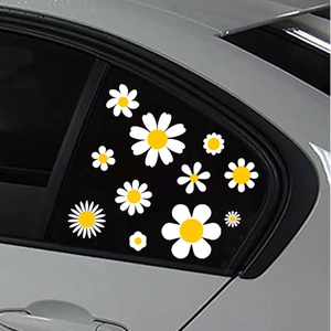 Detail von wasserdichten weißen Gänseblümchen-Aufklebern auf silberner Autofensterscheibe