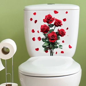 Detail of red rose stickers on a white toilet tank lid in a green bathroom setting