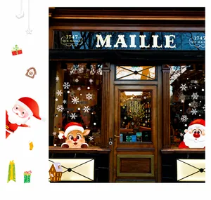 Dettaglio di adesivi natalizi per finestre con Babbo Natale e renne su vetro lucido