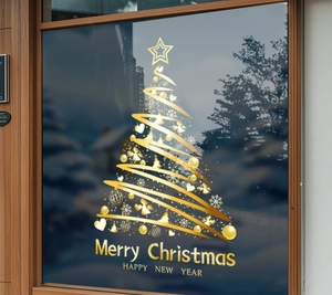Détail de stickers de Noël dorés pour fenêtre avec sapin et motifs de flocons
