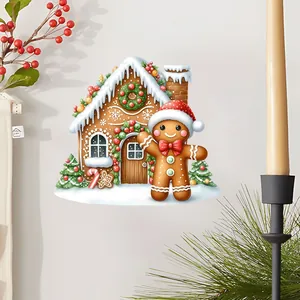 Détail sticker mural maison en pain d'épices avec neige et couronne sur mur blanc