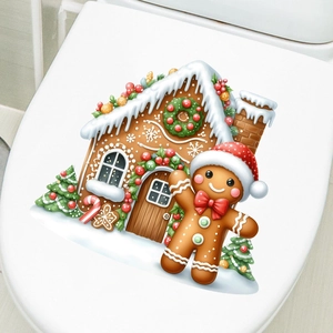 Détail des stickers bonhomme de pain d'épices et maison de Noël sur un abattant WC blanc
