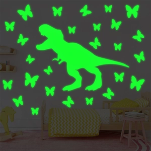 Luminous T-Rex and butterfly wall stickers glowing neon green in a dark kids bedroom