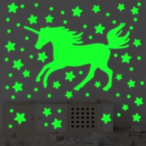 Luminous unicorn wall stickers with stars and dots glowing in a dark kid's bedroom