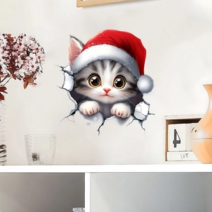 3D wall sticker featuring a cute grey kitten in a red Santa hat breaking through the wall