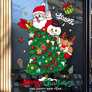 Détail d'autocollants du Père Noël et de rennes sur une vitrine en verre de magasin
