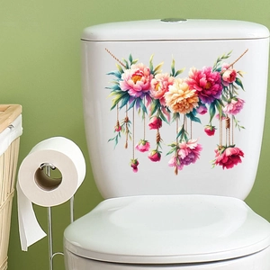 Dettaglio di un adesivo floreale con peonie rosa e foglie verdi su una cassetta WC