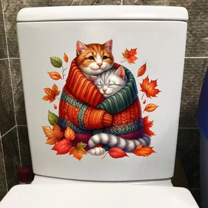 Close-up of cat wall decals with autumn leaves on a white ceramic bathroom surface