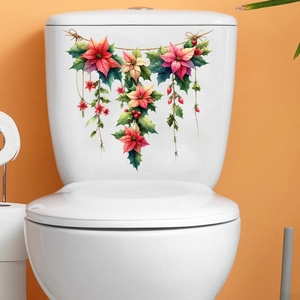 Dettaglio di adesivi natalizi floreali con fiori rossi e foglie verdi su un water in bagno