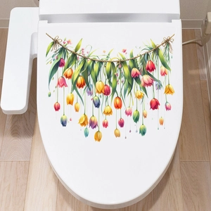 Dettaglio di adesivi floreali con tulipani e foglie verdi su un coperchio del WC bianco