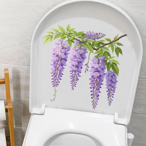 Self-adhesive purple wisteria flower stickers applied to a white bathroom toilet lid
