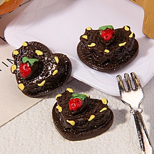 Macro shot of resin heart chocolate miniature cakes with strawberry on a white tray