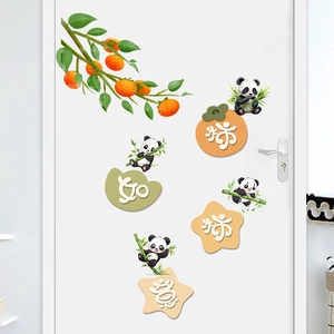 Detail of waterproof cartoon panda and persimmon stickers on a white interior door
