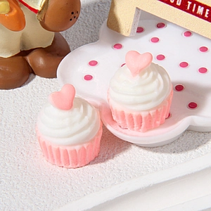 Gros plan de cupcakes miniatures en résine avec cœur sur un plateau nuage rose