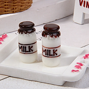 Detailed macro view of two miniature milk bottles with chocolate topping on a tiny tray