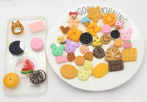 Detailed view of assorted resin charms for DIY crafts like cookies and cartoon shapes