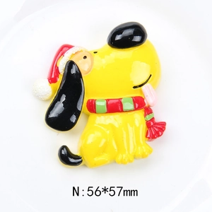 Macro shot of yellow cartoon dog resin craft with Christmas hat and size marking 56x57mm