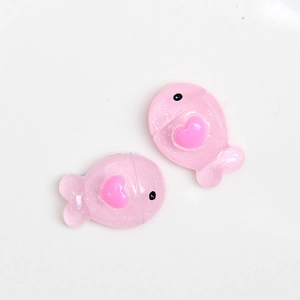 Détail de breloques poissons roses à paillettes en résine avec cœur pour projets DIY