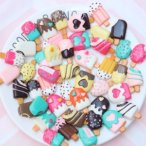 Flat lay of colorful resin ice cream charms with heart patterns for DIY phone case decor