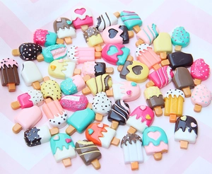 Macro shot of colorful resin ice cream accessories with heart and polka dot details for DIY crafts