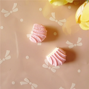 Vue macro de deux breloques en résine rose en forme de coquille pour artisanat DIY