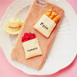 Détail d'une coque de téléphone en peluche avec mini croissant et tomate 3D