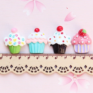 Bunte Cupcake-Harzanhänger für DIY-Bastelarbeiten und Handyhüllen auf einem Holzlineal
