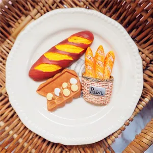 Gros plan d'aimants de boulangerie française en forme de baguette dans un panier vintage