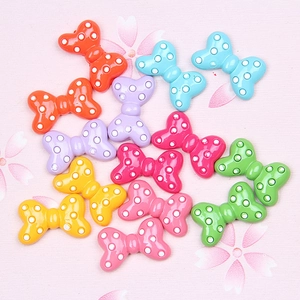 Detailed macro view of colorful resin polka dot bows for DIY jewelry and hair crafts