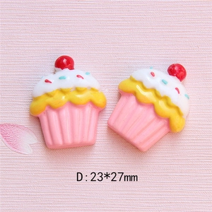 Detailansicht der 23x27mm Harz-Cupcake-Anhänger mit weißem Guss und roter Kirsche