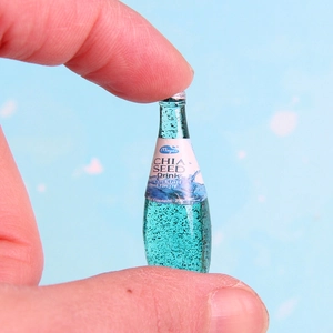 Miniature resin juice bottle for DIY jewelry featuring realistic chia seed drink details