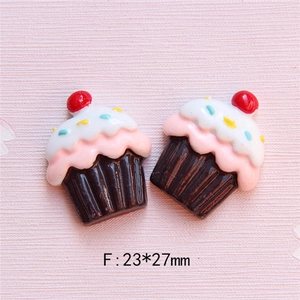 Makro-Detail von 23x27mm Harz-Cupcakes mit rosa Creme und Kirsche für DIY-Handyhuellen