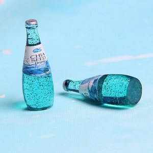 Macro shot of two miniature blue resin chia seed drink bottles for DIY jewelry making
