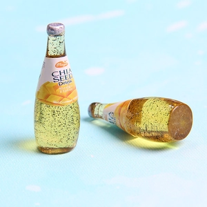 Macro shot of miniature resin mango juice bottles with chia seeds and silver caps