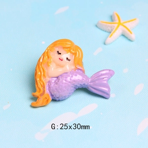 Detailed macro view of an orange-haired mermaid resin charm sized 25x30mm for DIY crafts
