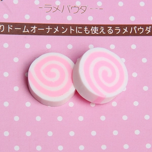 Detailed macro view of pink swirl polymer clay charms for DIY phone cases and nail art