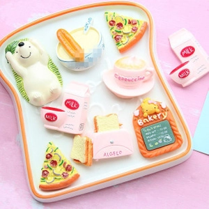 Macro view of cute resin food miniatures including bread and milk on a toast tray