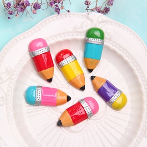 Close-up of colorful resin pencil DIY flatback charms for crafts in a ceramic dish