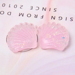 Macro-opname van roze hars schelpen hangers met sprankelende iriserende glittervlokken