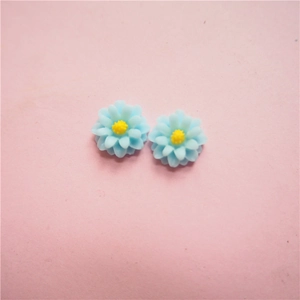 Detail of light blue resin daisy flower with yellow center for DIY jewelry making