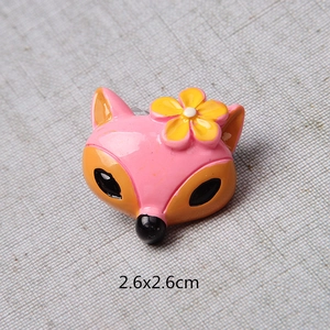 Détail d'une breloque renard en résine rose avec fleur jaune et mesure de 2,6x2,6cm