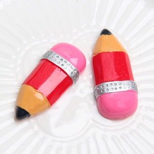 Macro detail of glossy resin pencil-shaped DIY accessories on a white porcelain plate