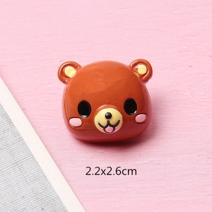 Détail d'une breloque ours en résine marron avec joues roses et taille 2,2x2,6cm