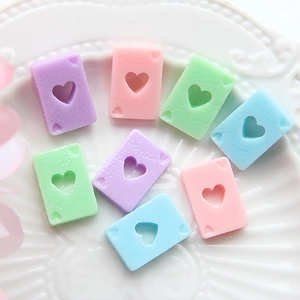Détails macro de pendentifs poker en résine aux tons macaron pour projets DIY créatifs