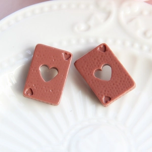 Détail macro de breloques poker en résine rouge avec découpe de cœur pour bijoux DIY